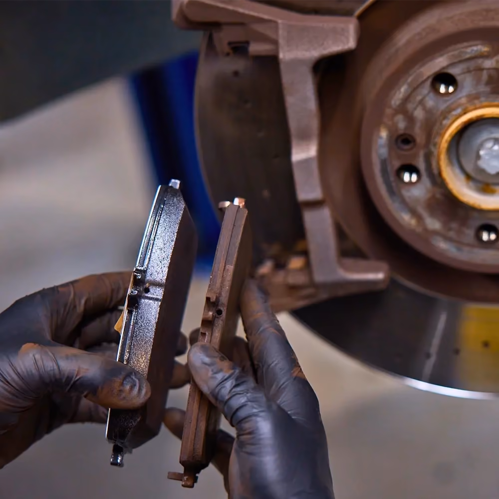 Technician servicing the brakes on a Mazda in the workshop.