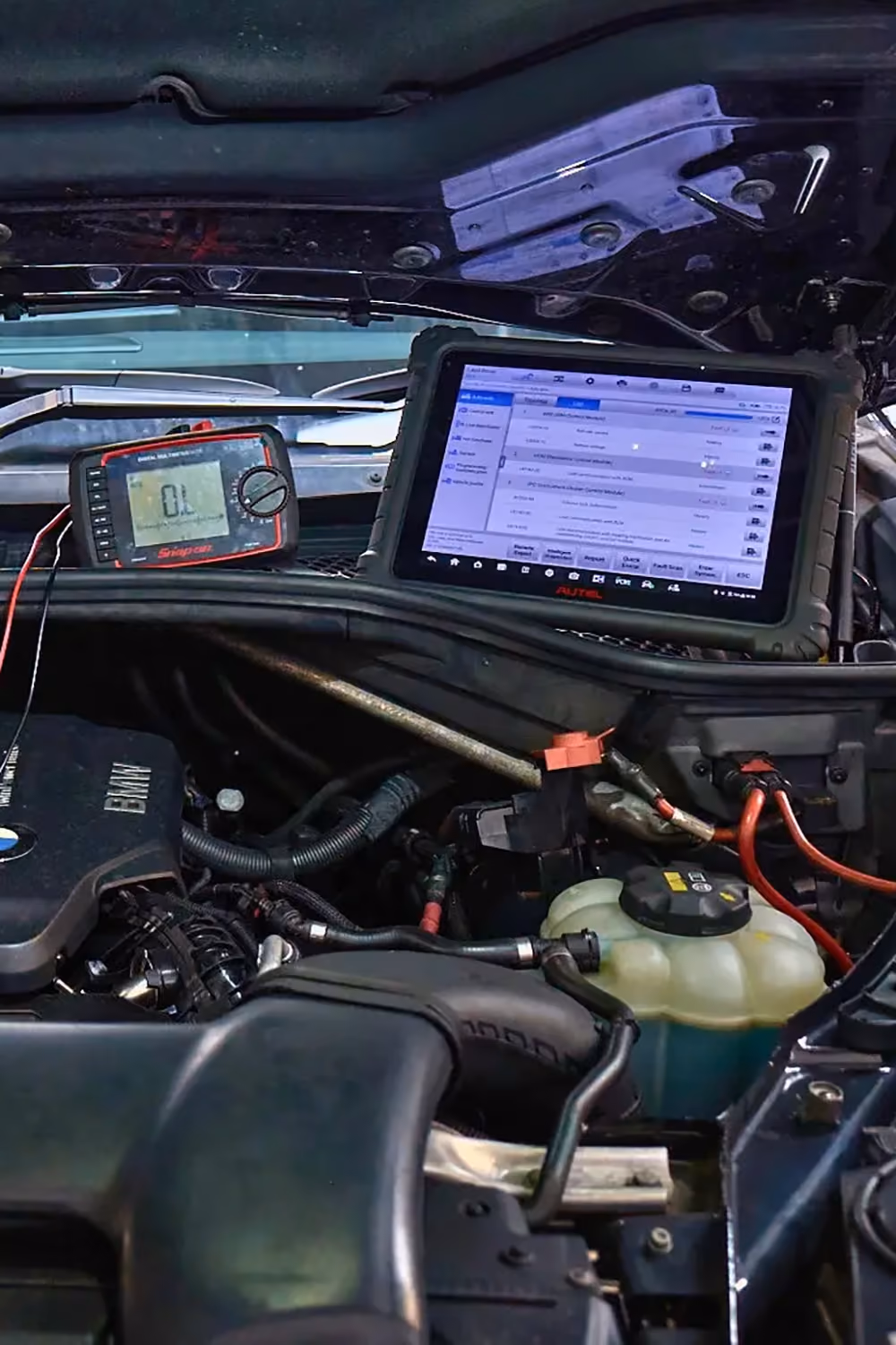 Vehicle undergoing computer diagnostics with a professional scan tool connected to the engine.