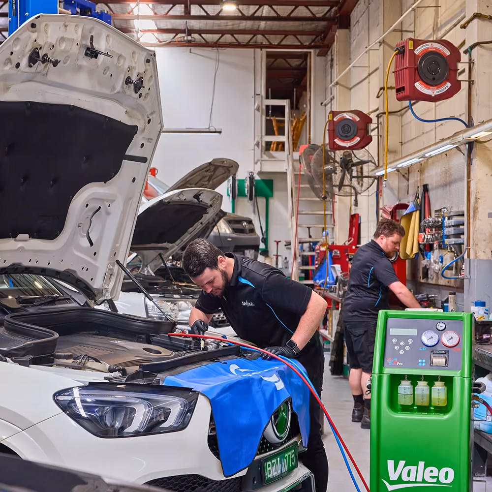 Technician performing routine maintenance on a prestige vehicle at Auto Tech Group's workshop.