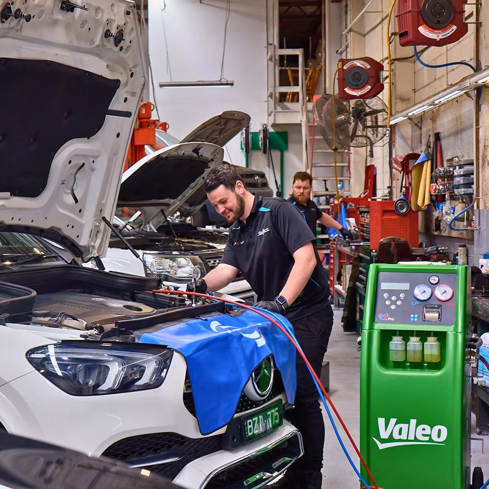 Technicians servicing prestige vehicles in the Auto Tech Group workshop with a Range Rover undergoing maintenance.