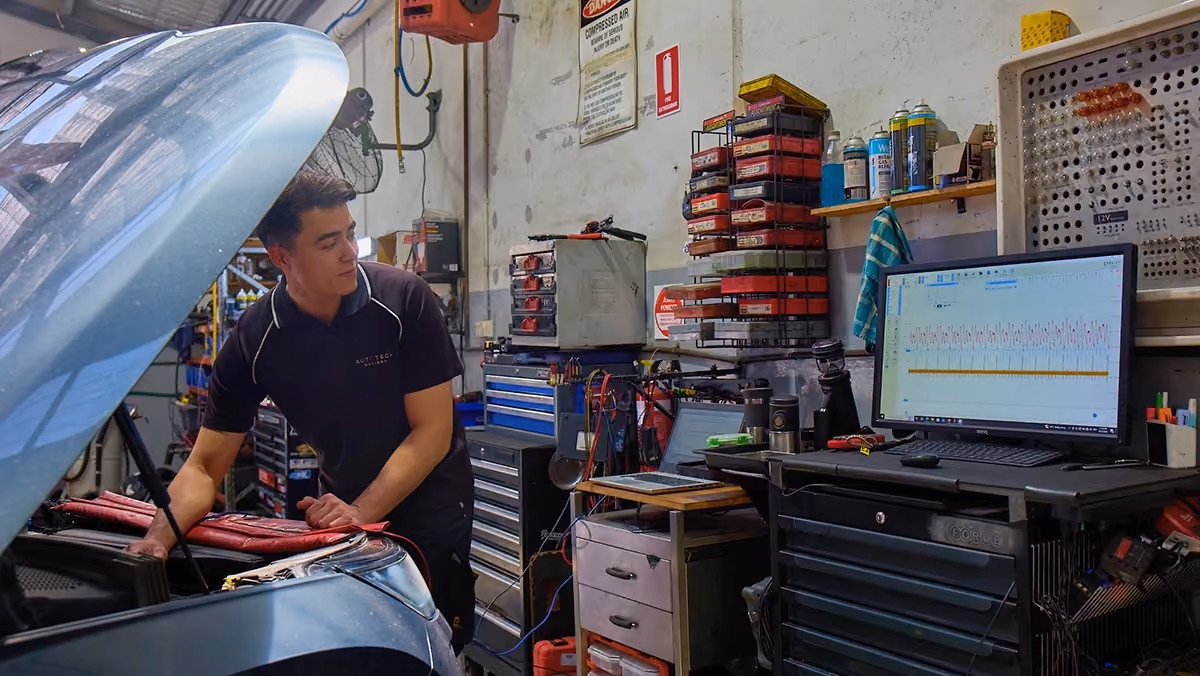 Technician checking a European vehicle using diagnostic software during a seasonal inspection.