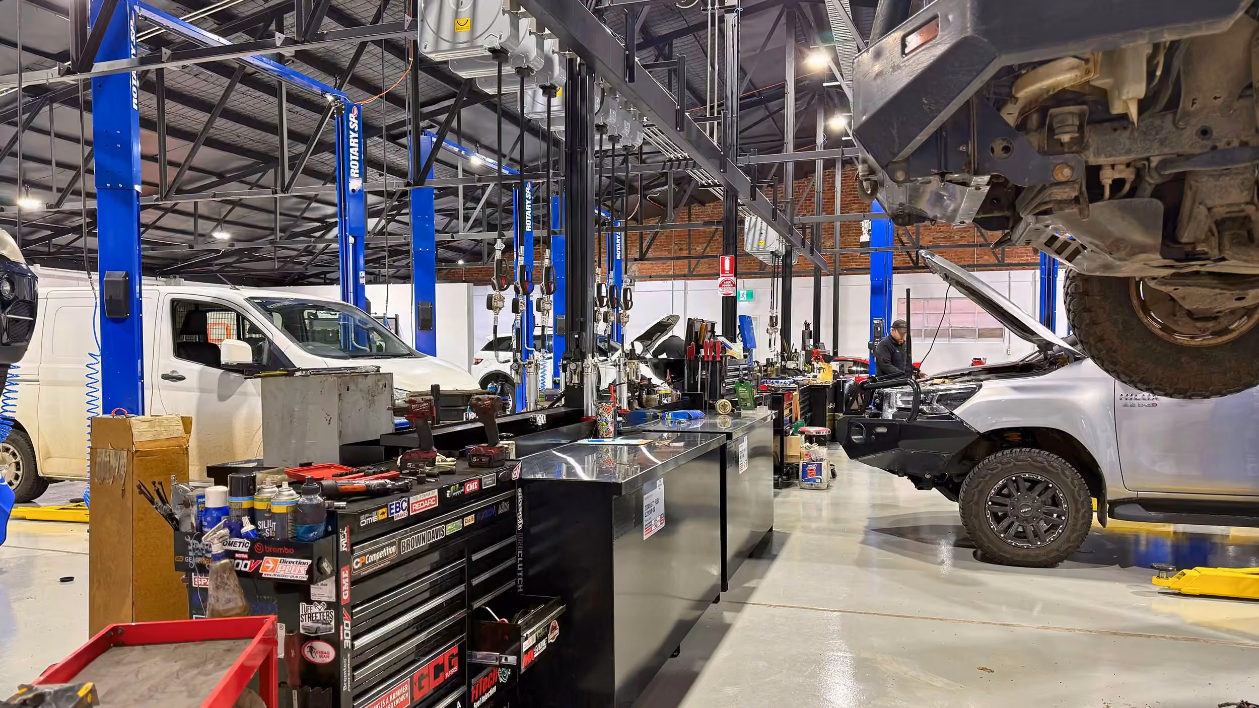 Interior of the Weir Street workshop with vehicles in multiple service bays.