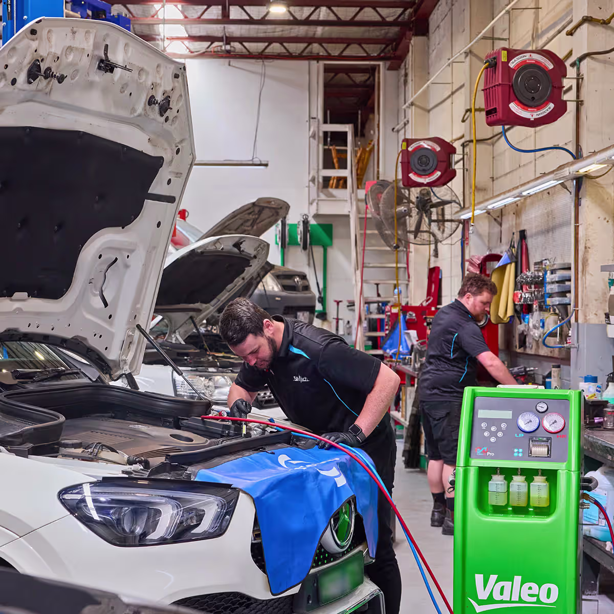 Technician performing routine maintenance on a prestige vehicle at Auto Tech Group's workshop.