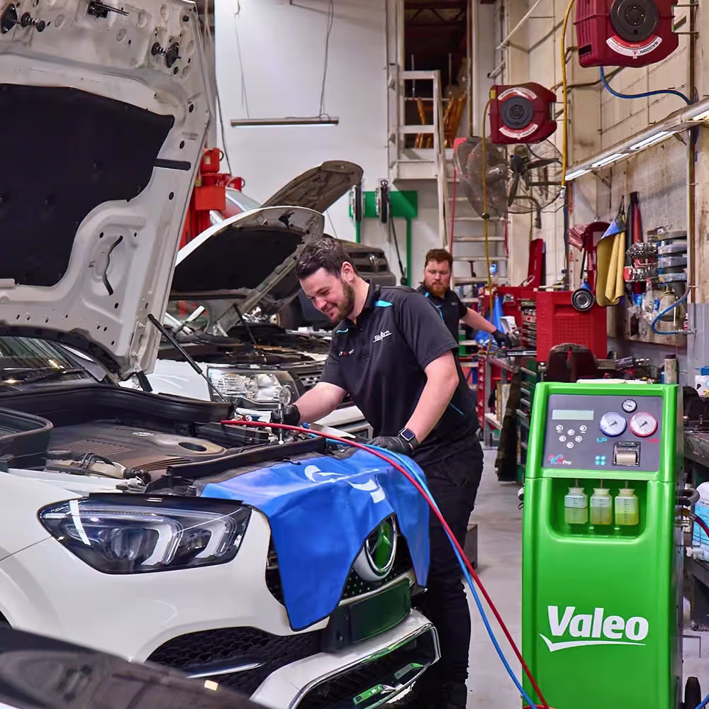 Technicians servicing prestige vehicles in the Auto Tech Group workshop with a Range Rover undergoing maintenance.
