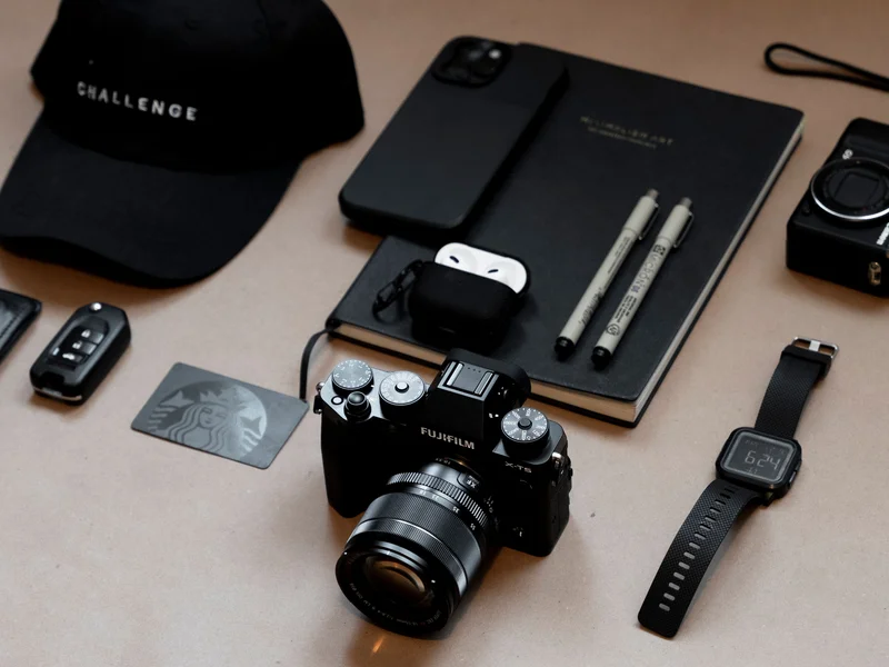 Creative desk flatlay with camera, notebook, and everyday tech and accessories