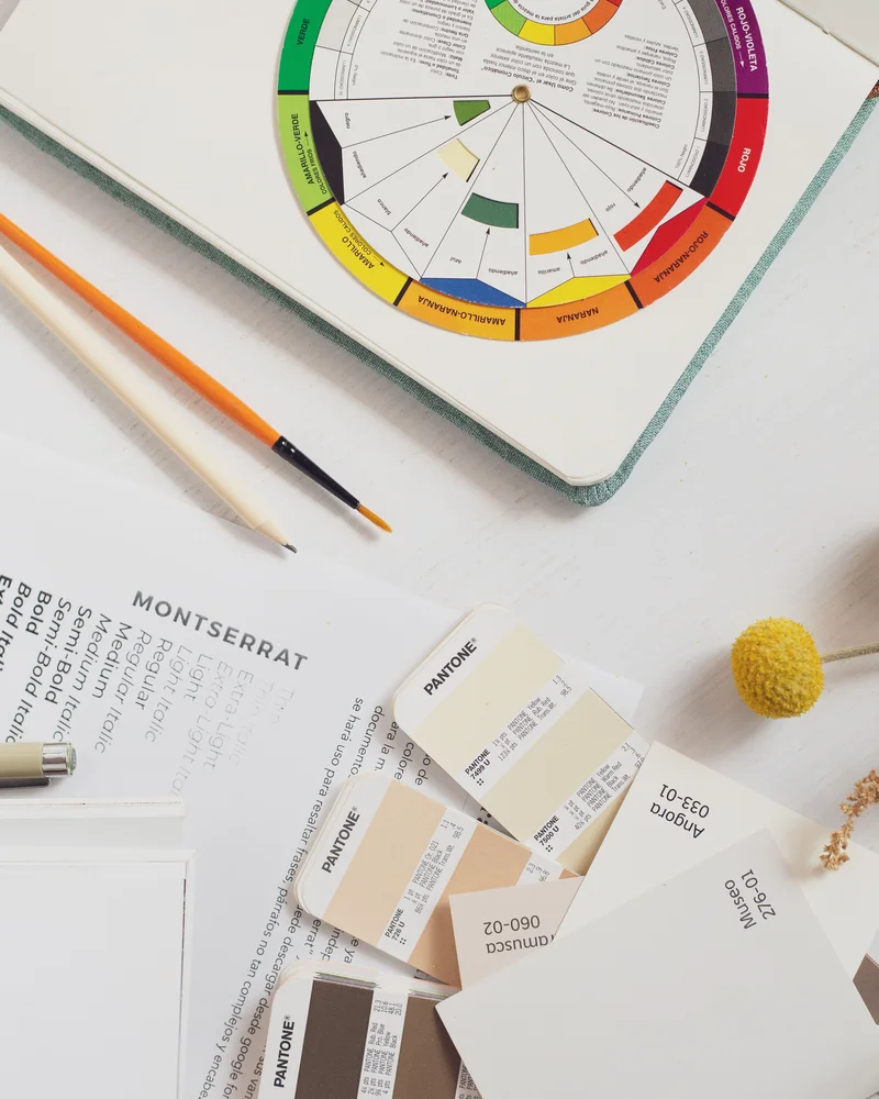 Color wheel, Pantone swatches, and a font specimen sheet laid out for a brand audit