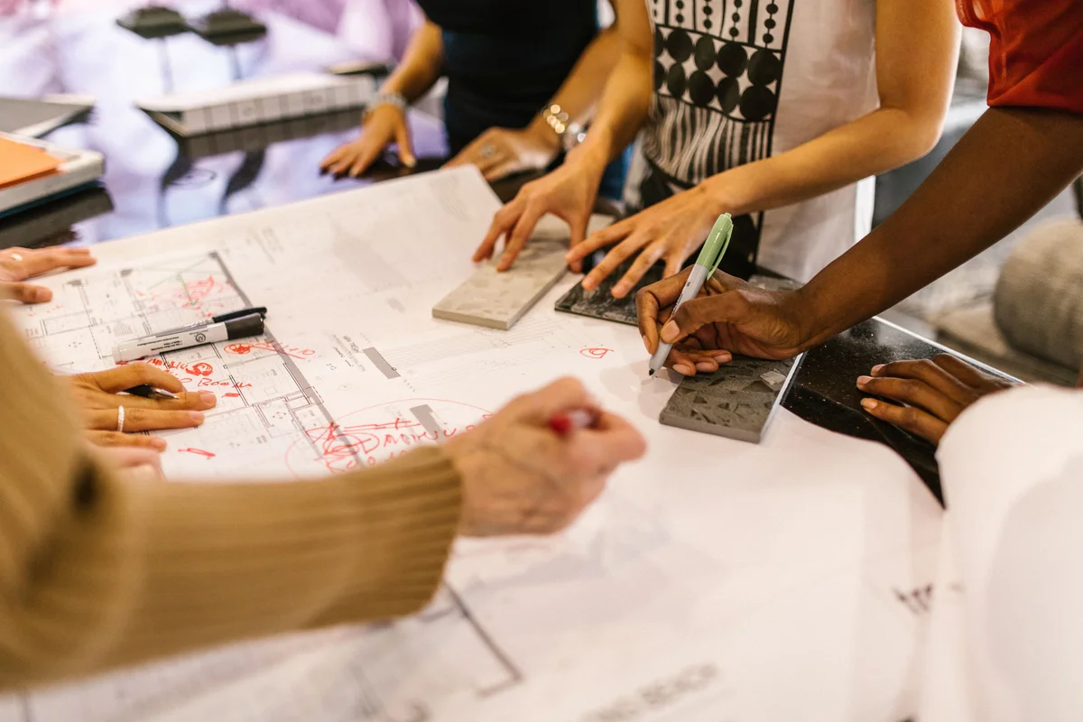 A team collaborating around a table reviewing samples and materials
