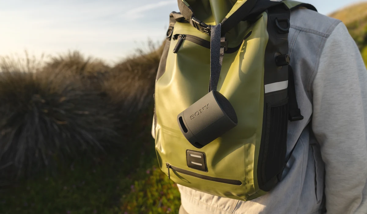 A branded backpack with a portable speaker clipped on, ready for a launch activation outdoors