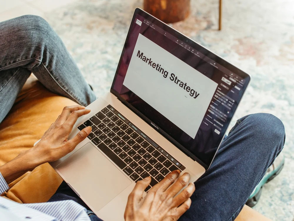 Marketing manager working on a laptop with a marketing strategy document open