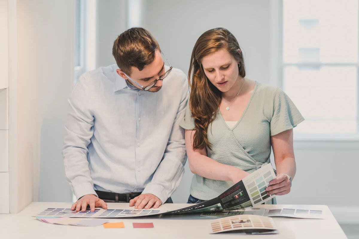 Two people reviewing color and material samples together at a desk