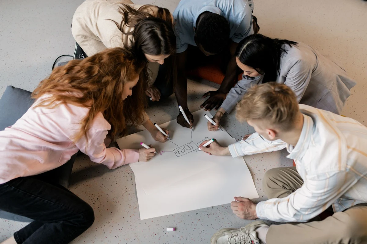 Creative team gathered around a table sketching out brand ideas together