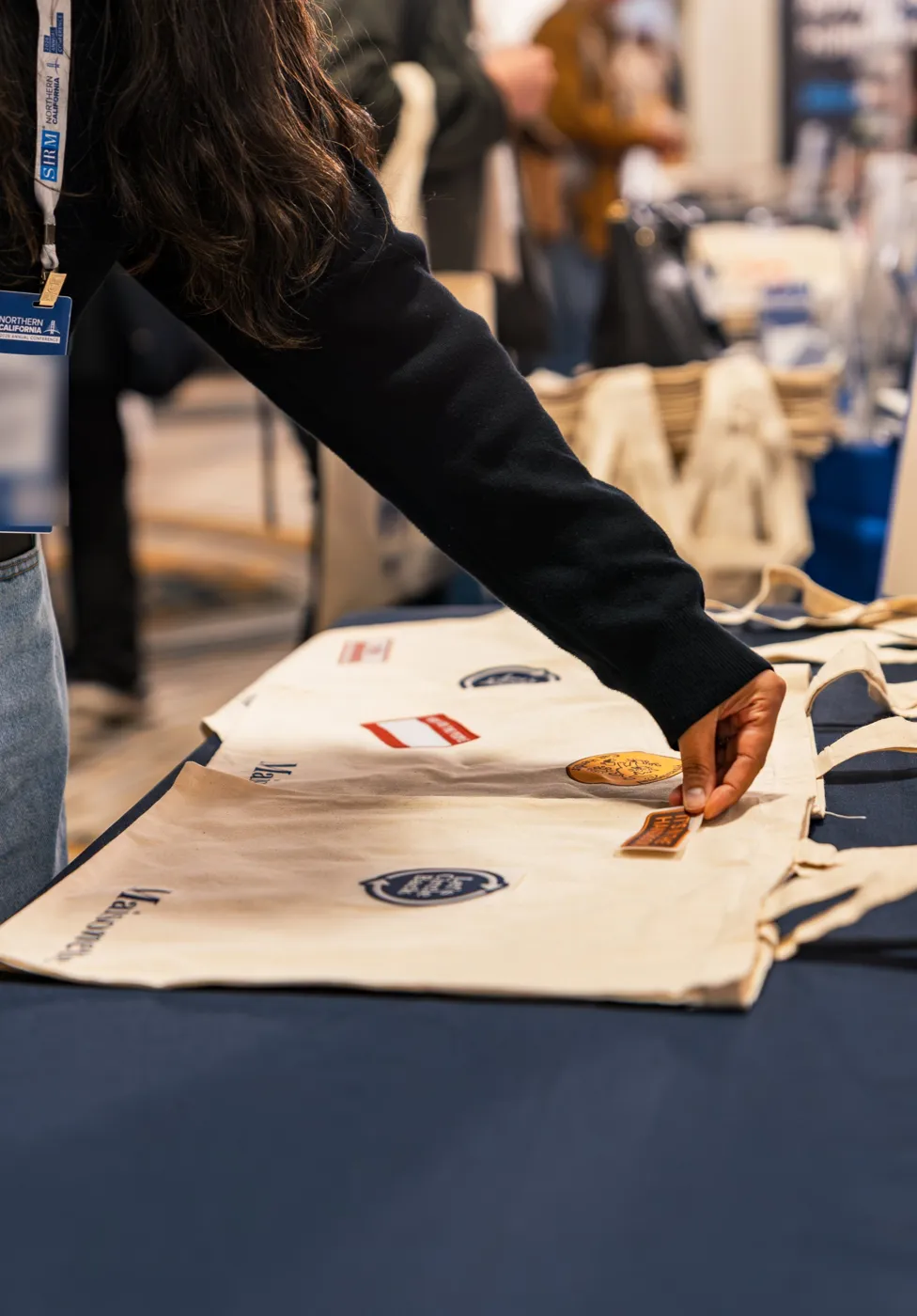 A guest placing a patch on a canvas tote before it is heat pressed