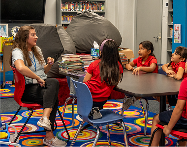 Teacher leading a small group discussion with students in library