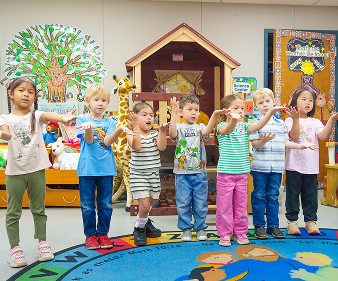 Young students singing and dancing together in a colorful classroom