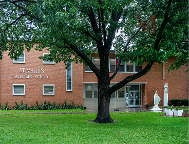 St. Mary's Catholic School brick building exterior with statue and tree
