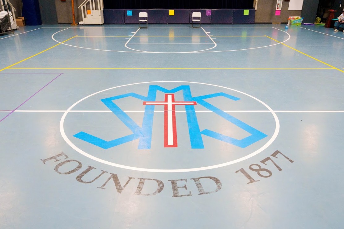 SMS school gymnasium floor with founding year 1877 logo