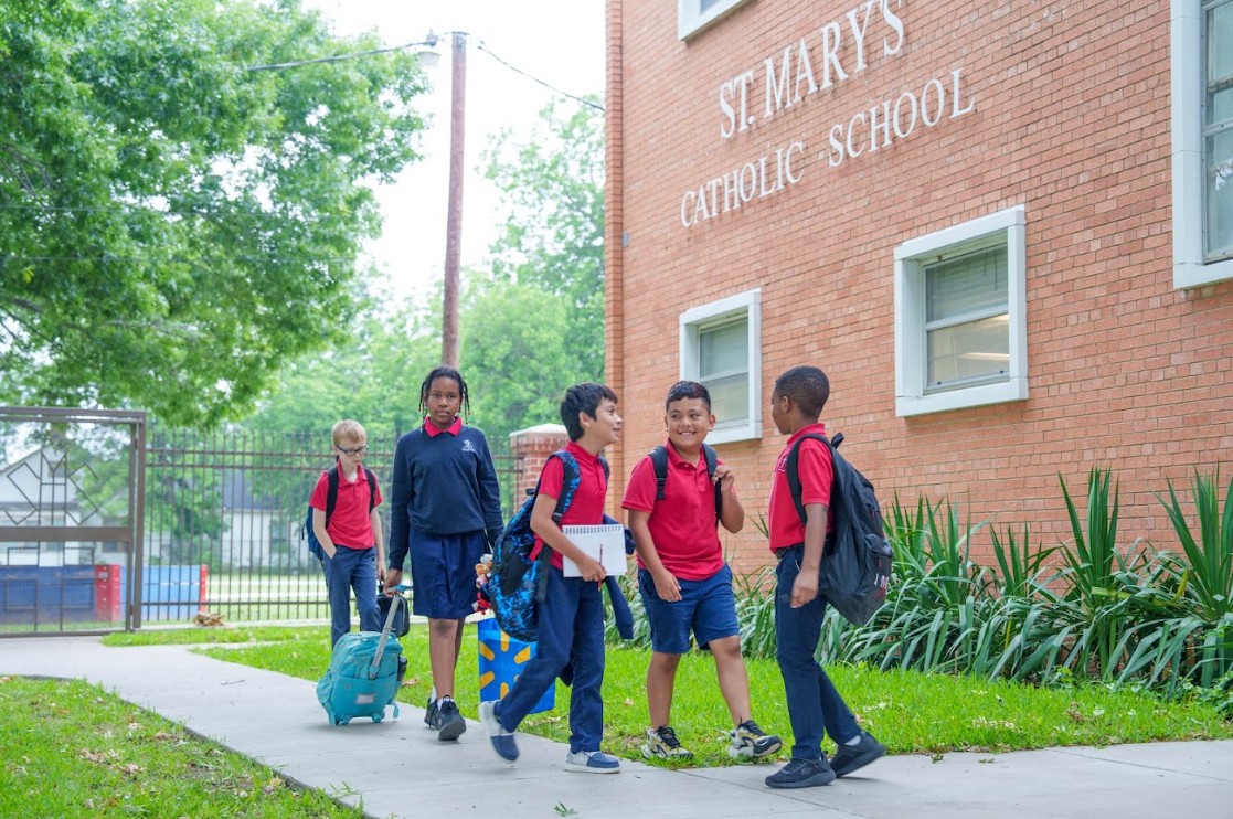 Students in uniform walking outside St. Mary's Catholic School building