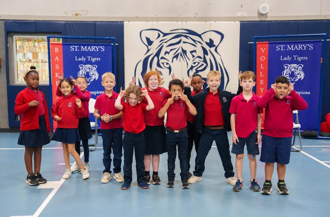 St. Mary's students posing in school gymnasium with Tiger mascot