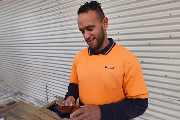 Man wearing hi-vis jacket using site app pro on his phone