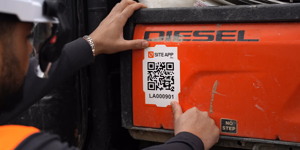 Worker pointing to a Site App QR code asset tag on red diesel plant equipment