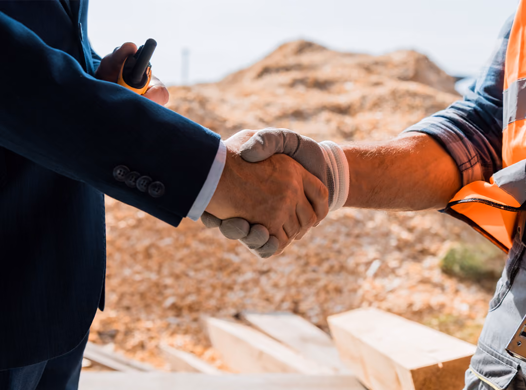 two people shaking hands on a construction site