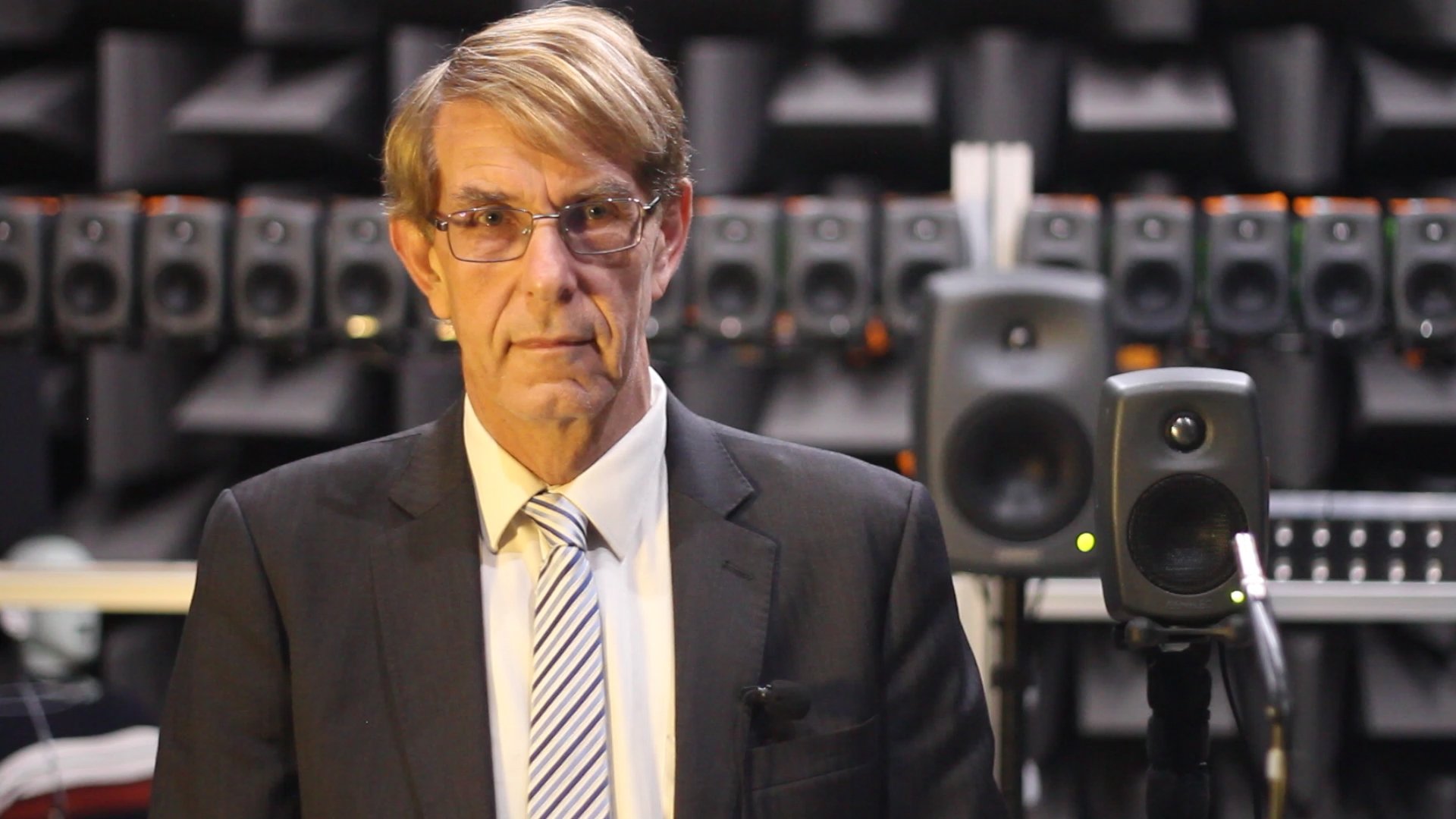 Paul Monsted, Noizend co-founder, standing in front of studio monitors in an anechoic chamber