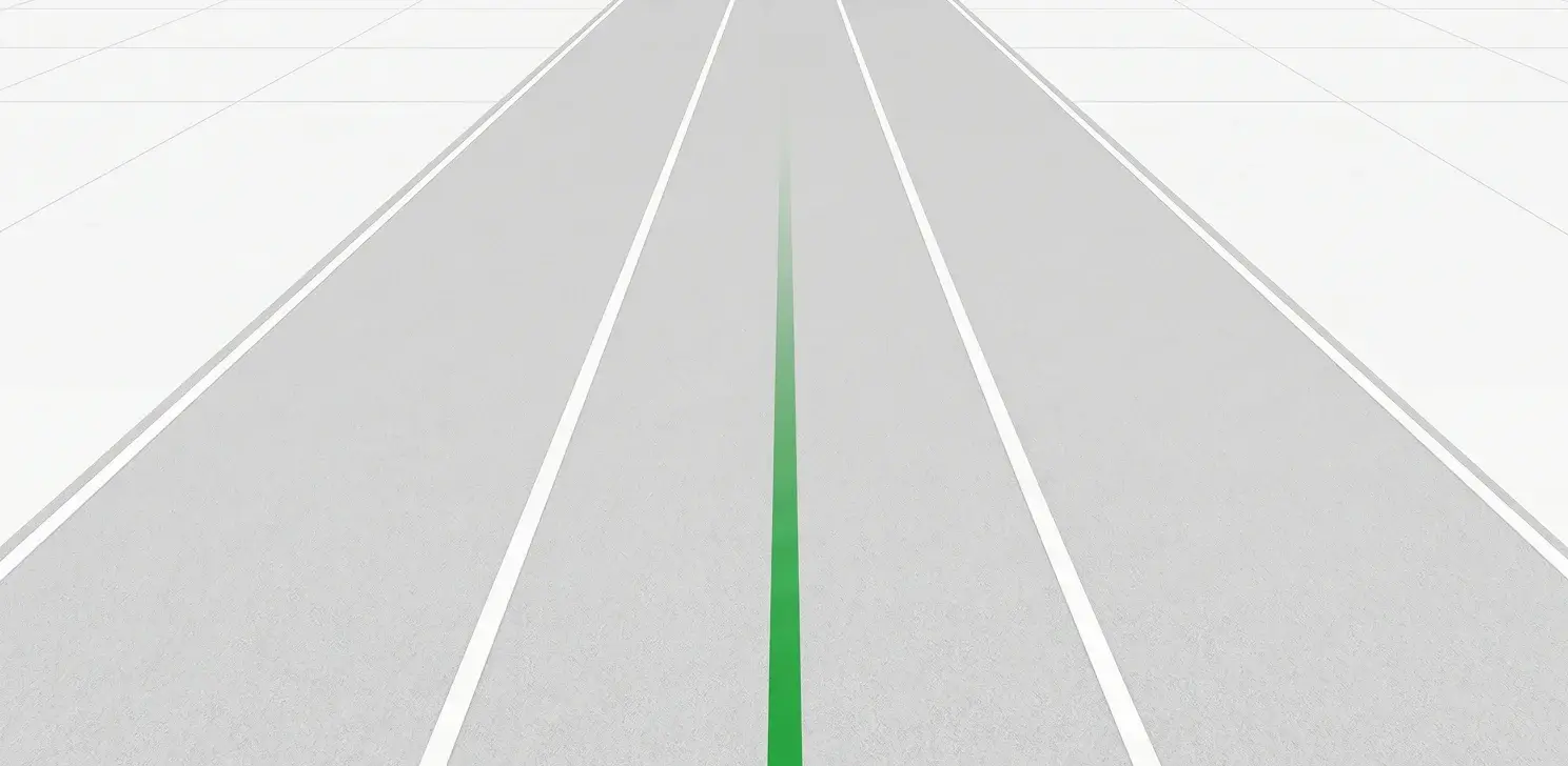 Straight, empty road with white lane markings and a faded green center line extending into the distance.