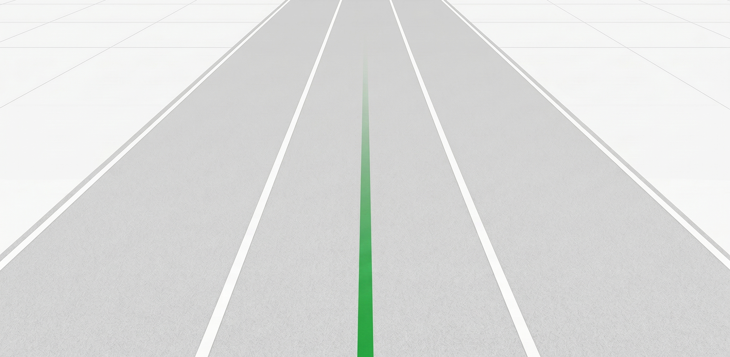 Straight, empty road with white lane markings and a faded green center line extending into the distance.