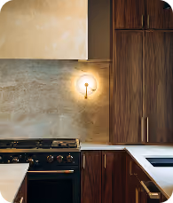 Modern kitchen with dark wood cabinets, a black stove, white countertop, and a wall light fixture.