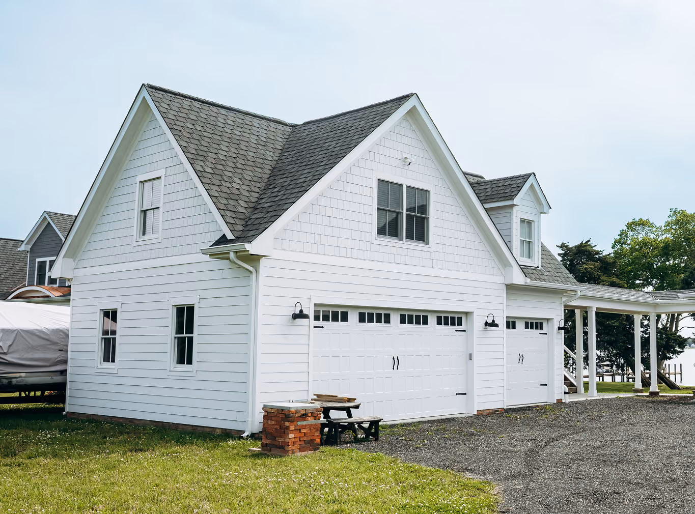 White two-car garage with a finished apartment above and a covered side porch