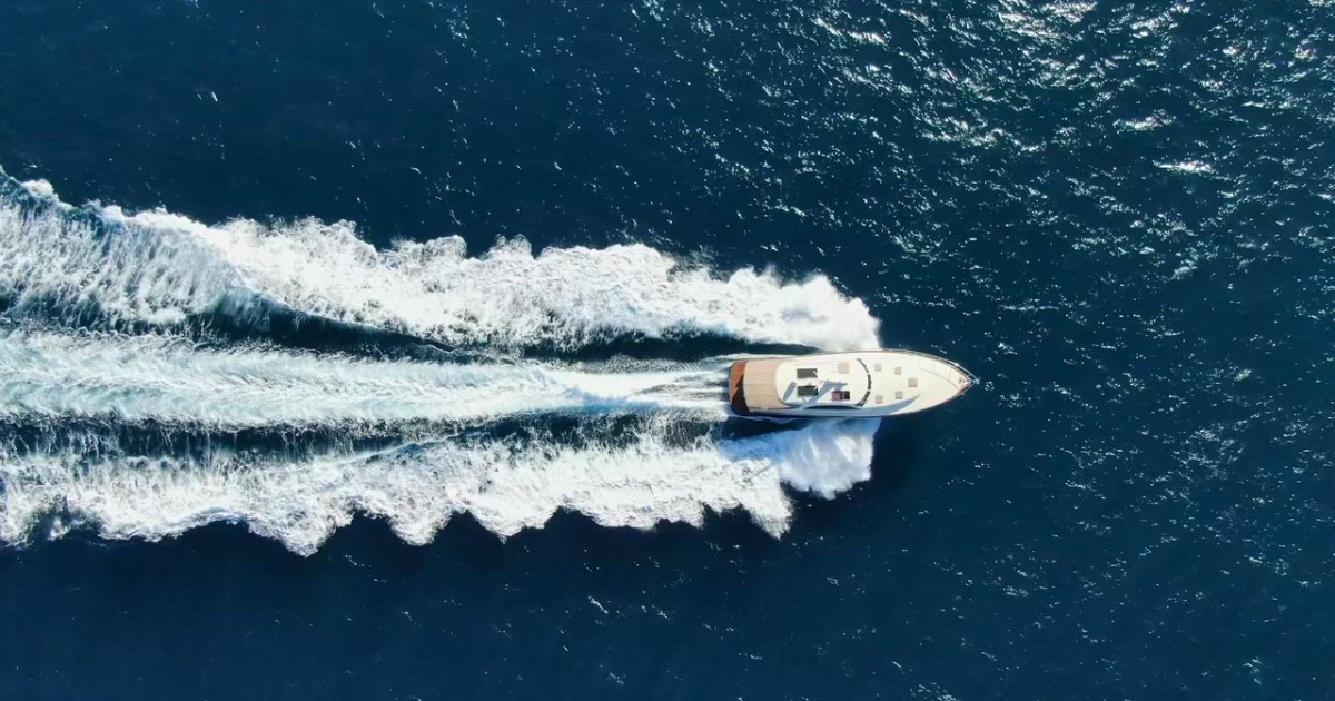 Aerial view of a motor yacht cruising across deep blue open ocean