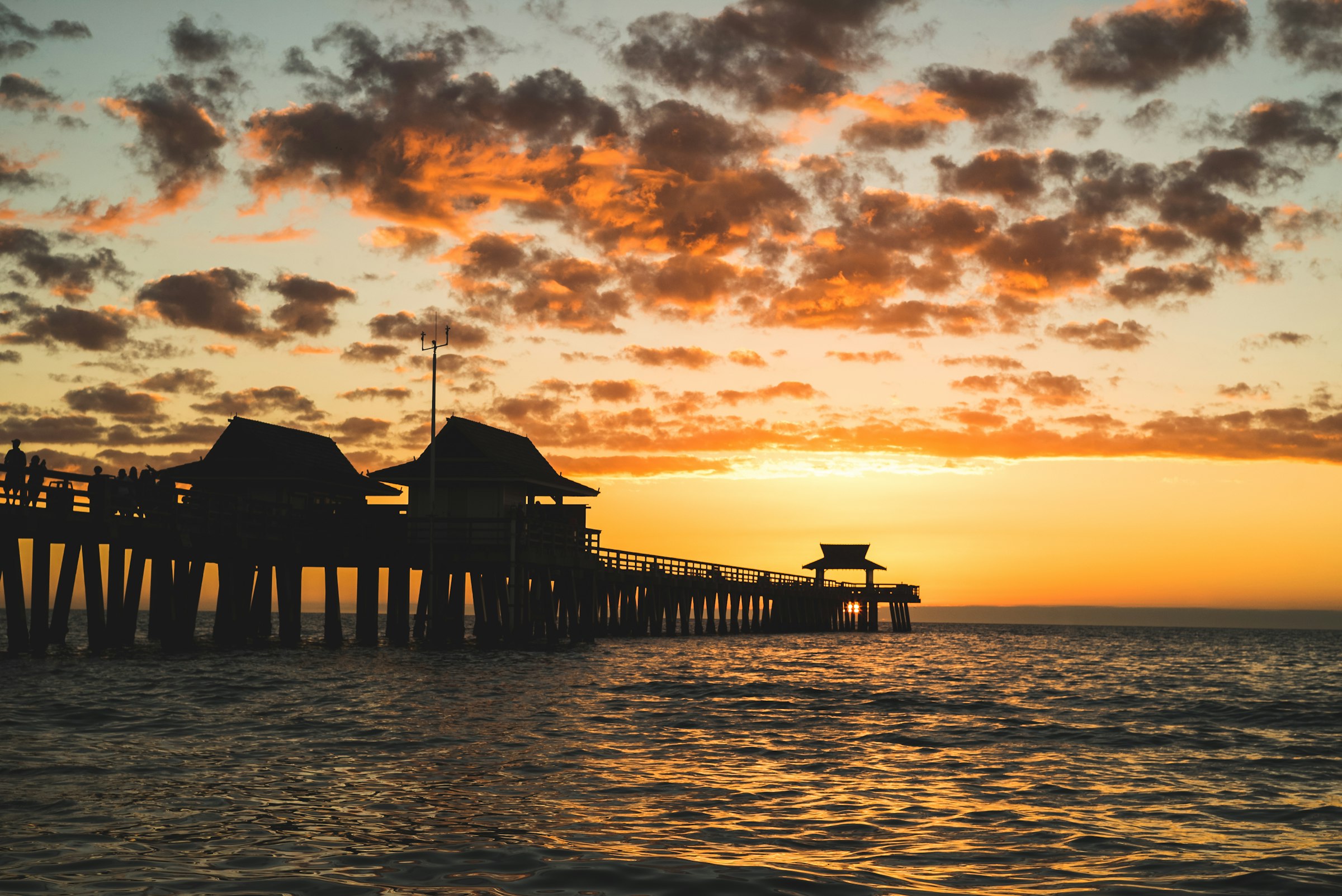 The Naples Pier in silhouette at sunset over the Gulf of Mexico, Naples, Florida