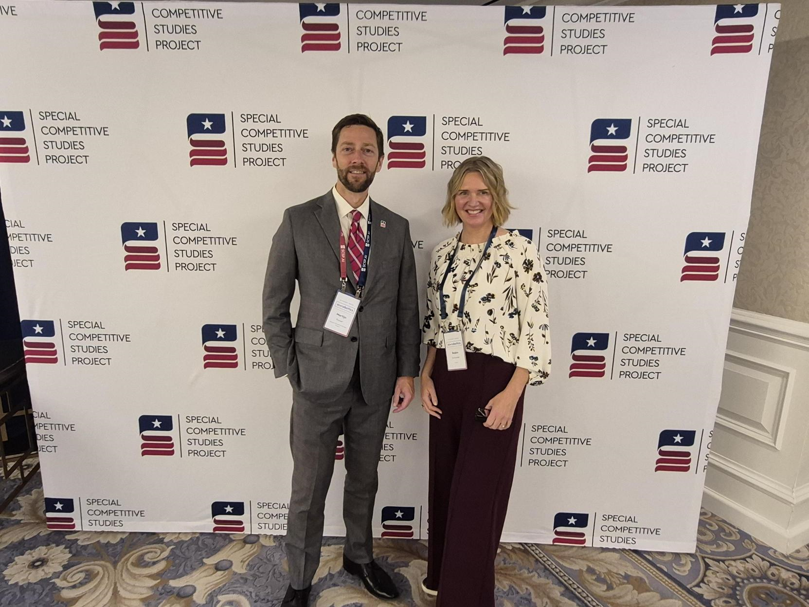 Martijn Rasser of SCSP and Robin Schneider of Enovix standing in front of an SCSP backdrop at the AI+ Robotics Summit.  Caption: Martijn Rasser, SCSP’s Vice President, Technology Leadership Directorate, with Robin Schneider, PhD, Director of Technical Product Marketing at Enovix, at the AI+ Robotics Summit in Washington, DC.