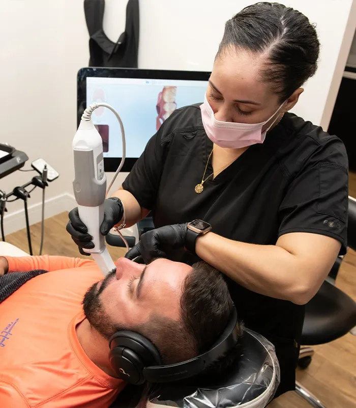 Dental professional using an intraoral scanner to capture a patient’s teeth during a digital dental examination.