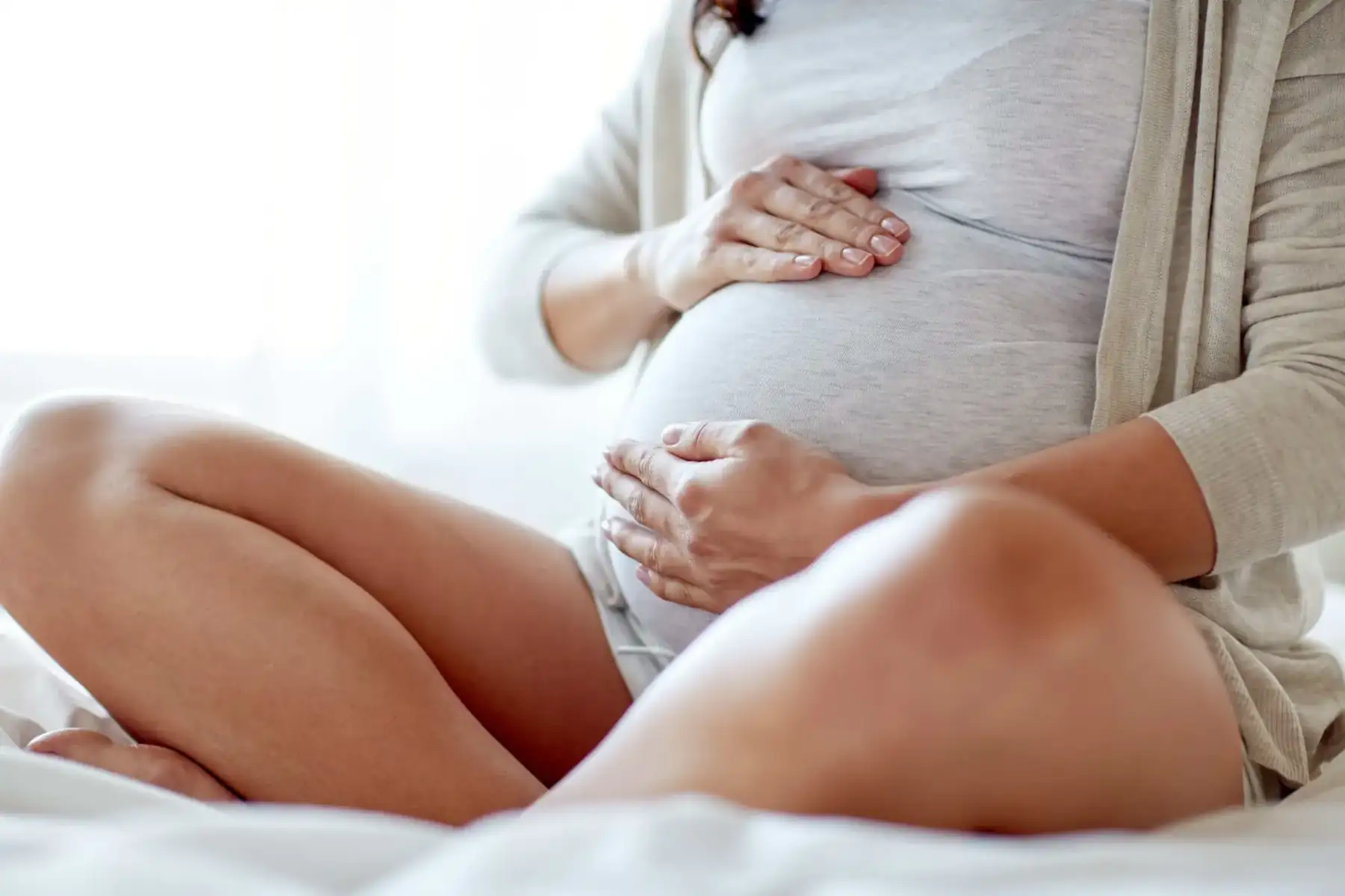 femeie însărcinată așezată pe pat | Control prenatal după 35 de ani