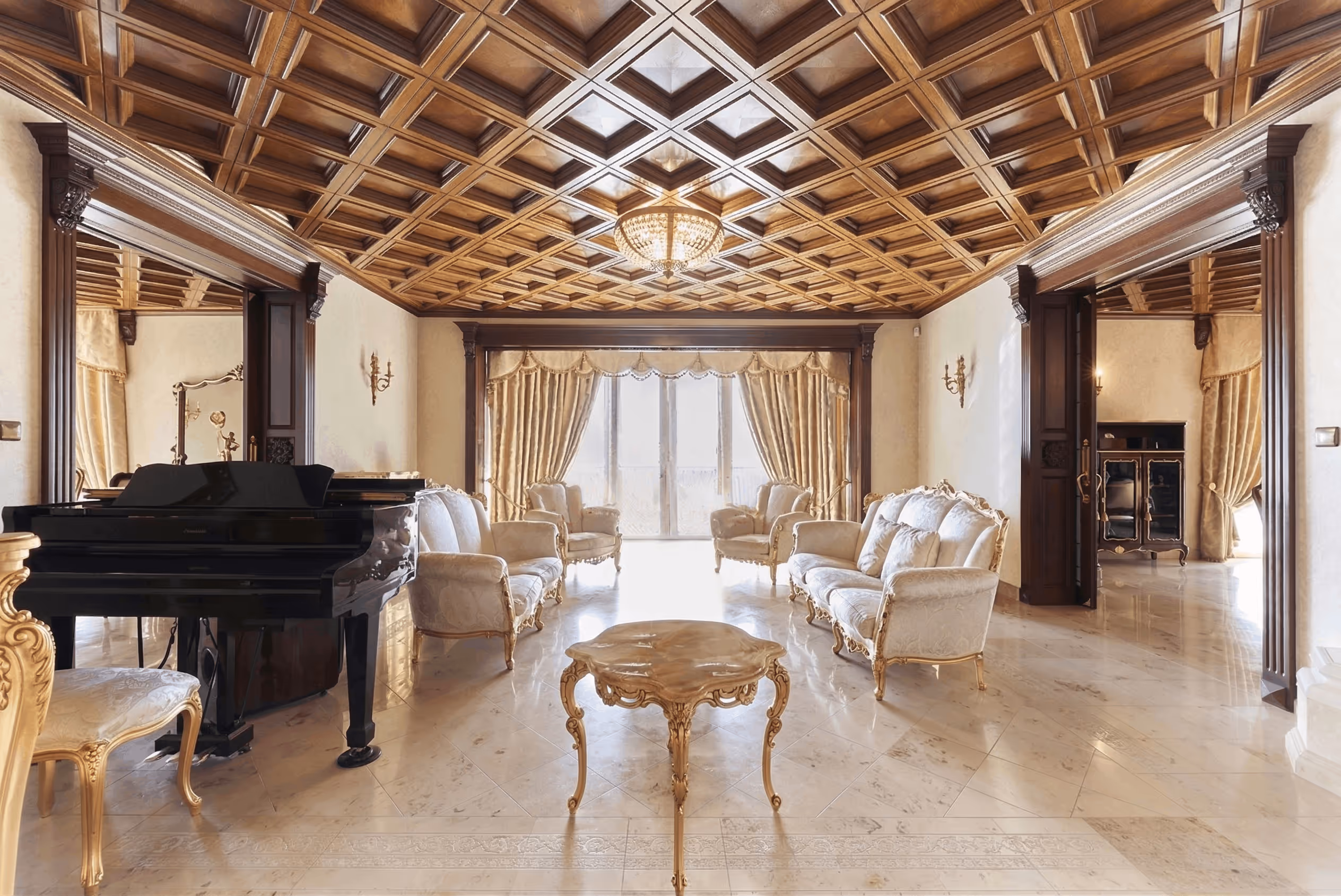 Elegant living room with ornate wood ceiling, gold-trimmed sofa set, marble floor, and grand piano.