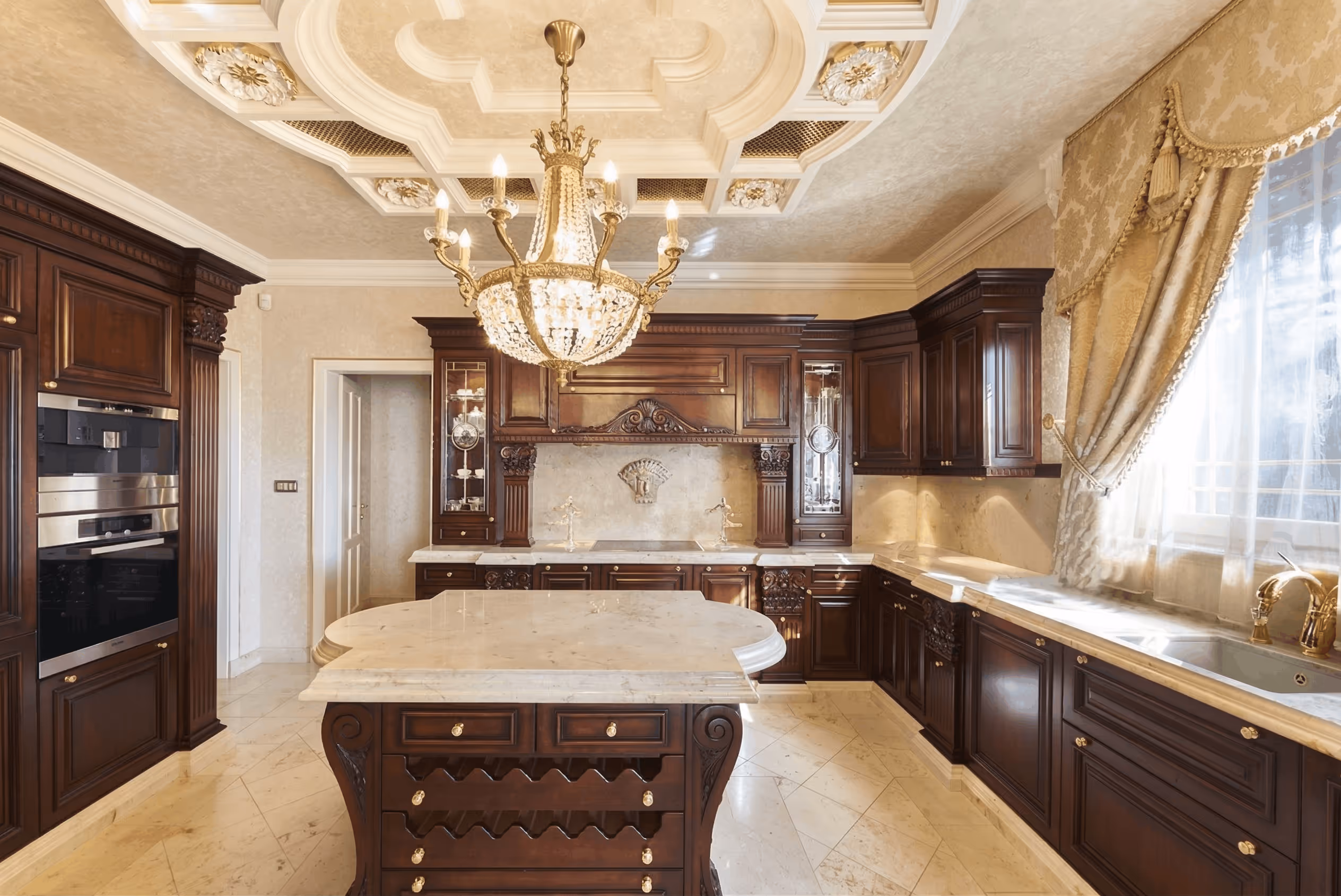 Elegant kitchen with dark wood cabinets, marble countertops, center island, chandelier, and large window with drapes.