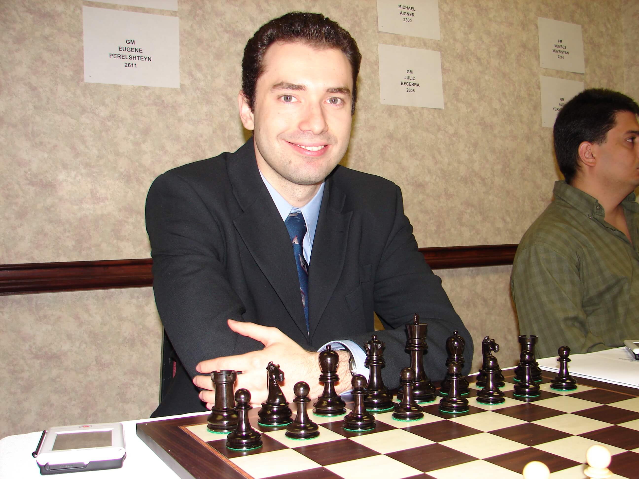 Photo of Eugene Perelshteyn sitting in front of a chess board, looking at the camera