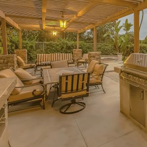View of a beautiful patio complete with chairs, tables, and a tiled floor.
