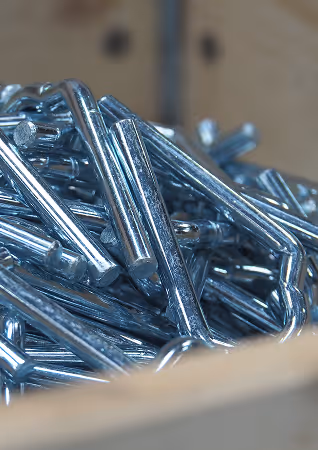 Close-up of shiny metal cotter pins piled together in a container.
