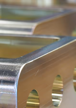 Close-up of a shiny metal object with rounded edges and circular cutouts.