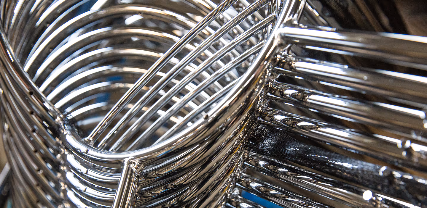 Close-up of shiny stacked metal chairs with tubular frames.