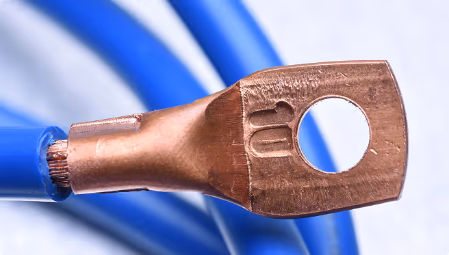 Close-up of a blue electrical wire with a copper terminal lug stamped with '10'.