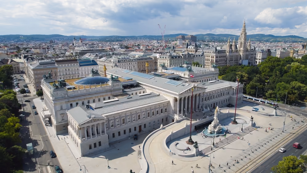 View over the rooftops of Vienna with St. Stephen's Cathedral and the Vienna Woods in the background.