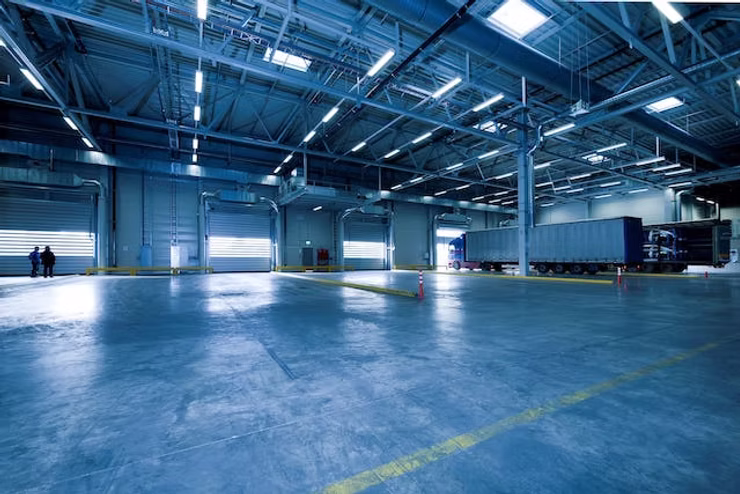 The image shows an empty warehouse which emphasizes the need for strategic planning when evaluating the pricing strategy of a small business.