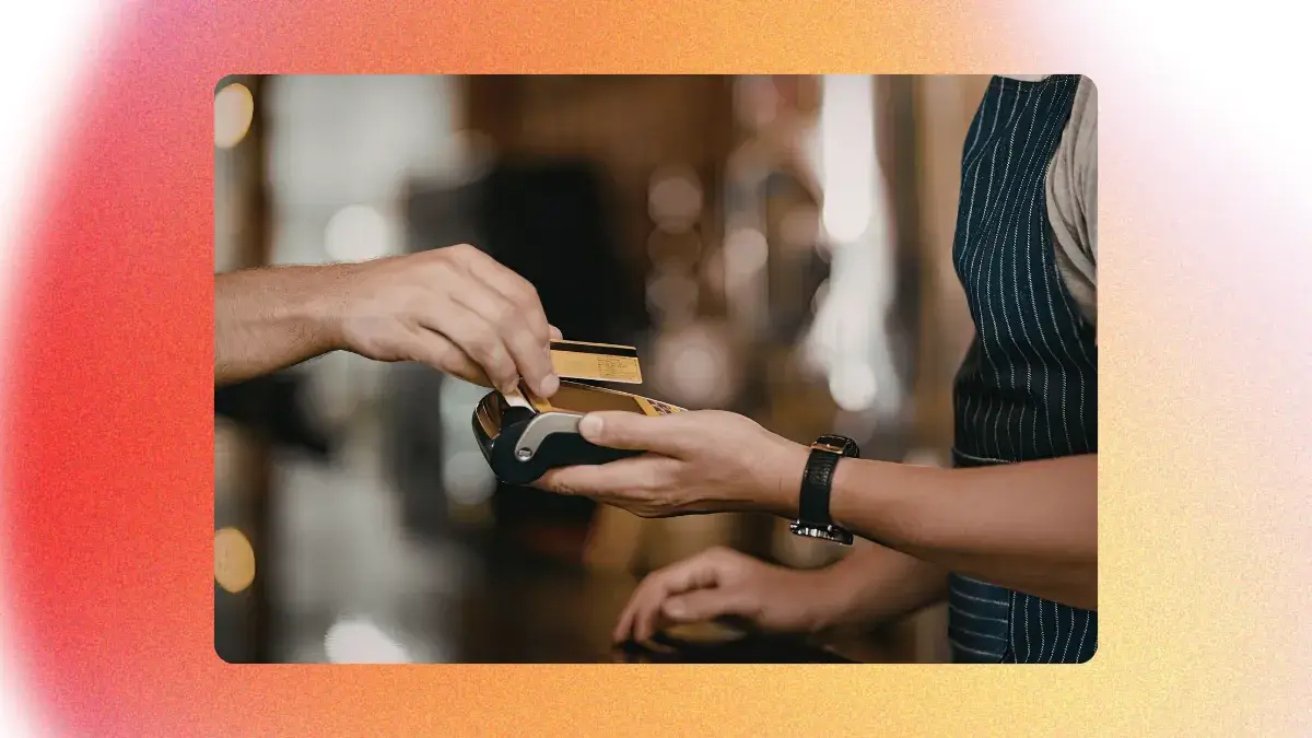 Client effectuant un paiement par carte bancaire sans contact sur le terminal d'une banque traditionnelle dans un restaurant.