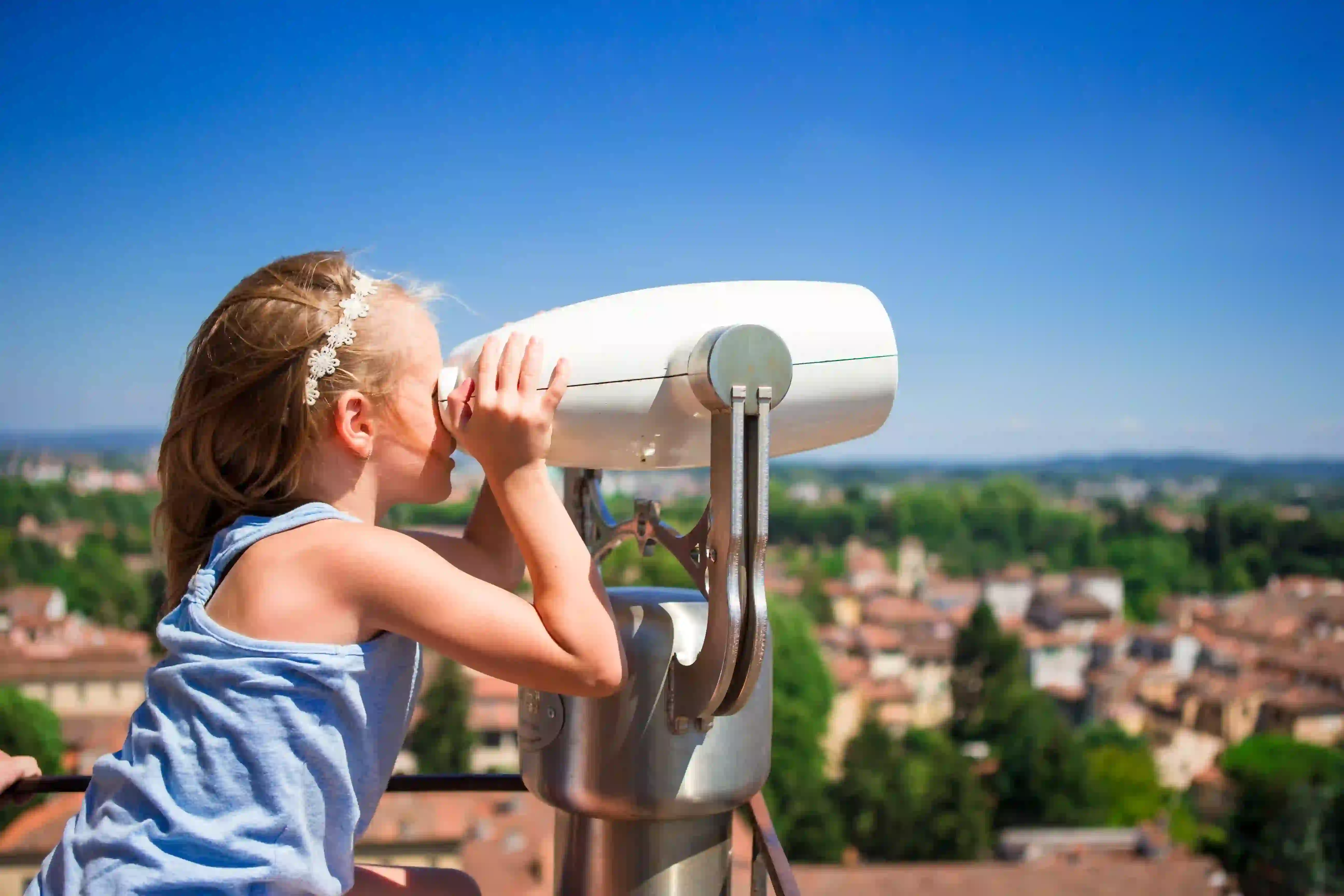 Young girl looking through a monoscopic to represent increased visibility as a result of sustainable sourcing and procurement policies.