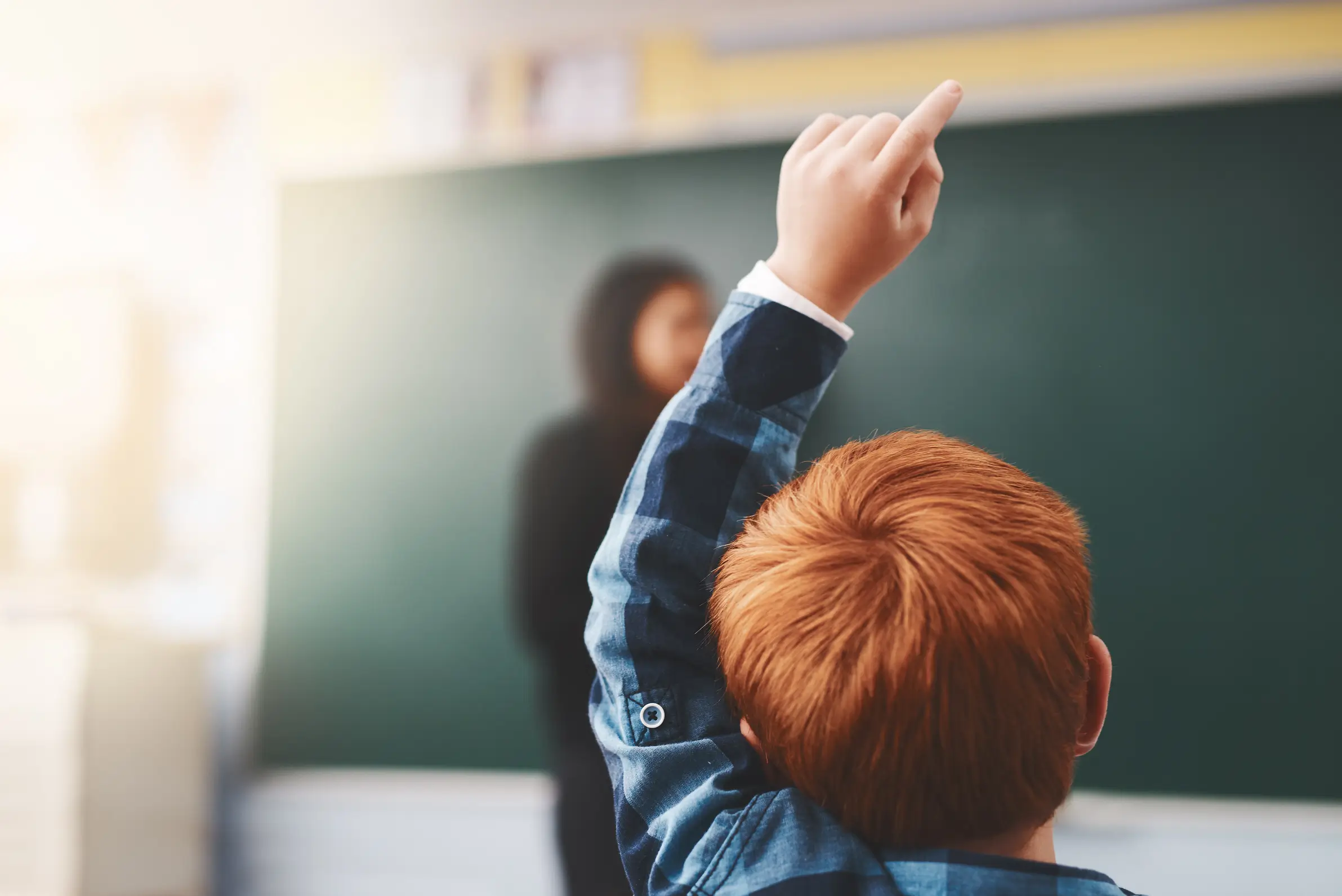 Kid raising hand in school to represent importance of asking questions in a healthy vendor relationship