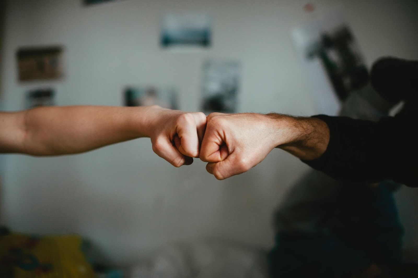 two people bumping fists with only arms in the photo to represent long-term partnerships and collaborations.