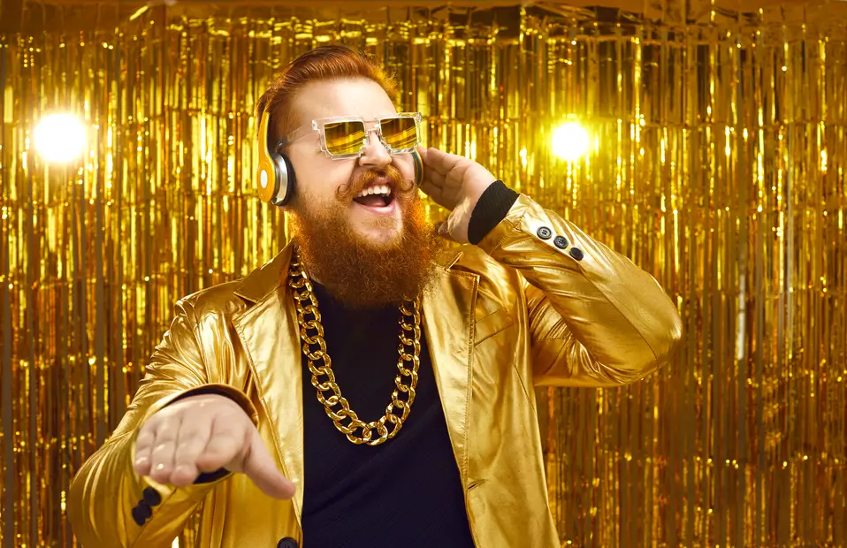 Man dressed in a gold jacket with gold background and gold chain to represent cost savings generated by strategic category management.